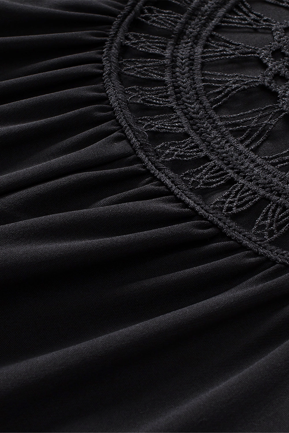 Black tunic fabric with embroidered crochet edge along gathered seam