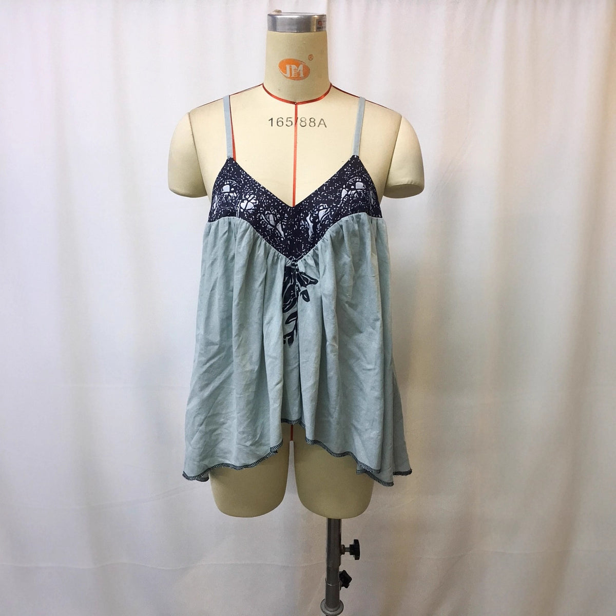 Light blue patchwork cami top with black printed V yoke on mannequin
