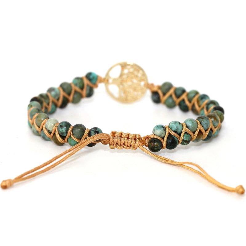 Green stone wrap bracelet with gold round tree charm and braided leather cord ties.