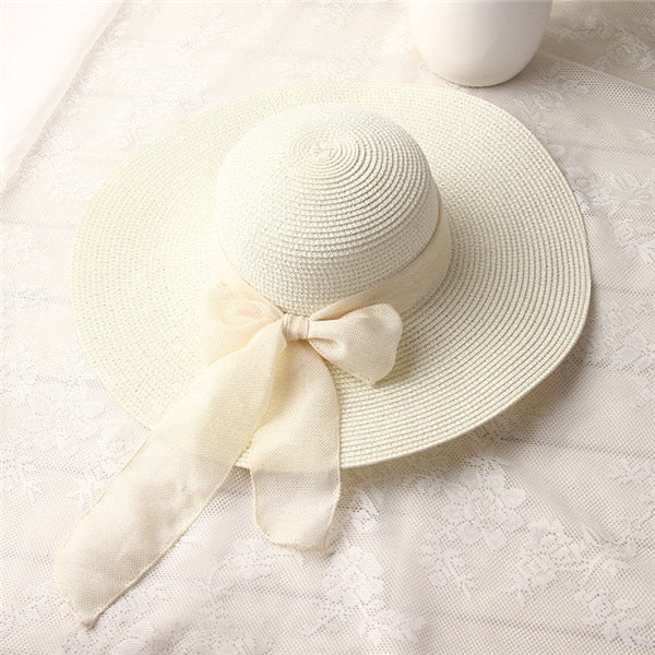 Ivory wide-brim straw sun hat with long ribbon bow