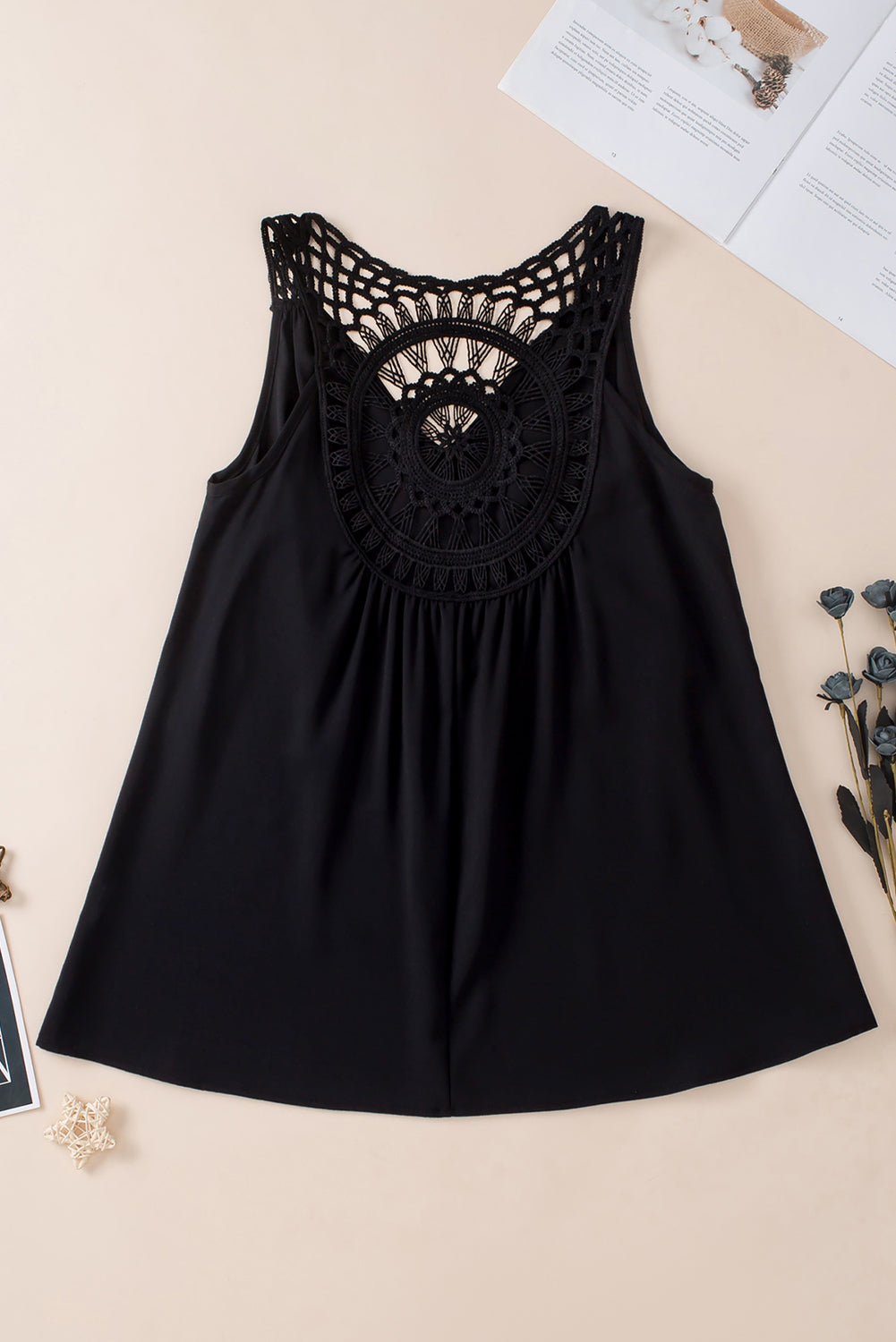 Black sleeveless tunic laid flat with crochet neckline and round embroidered yoke