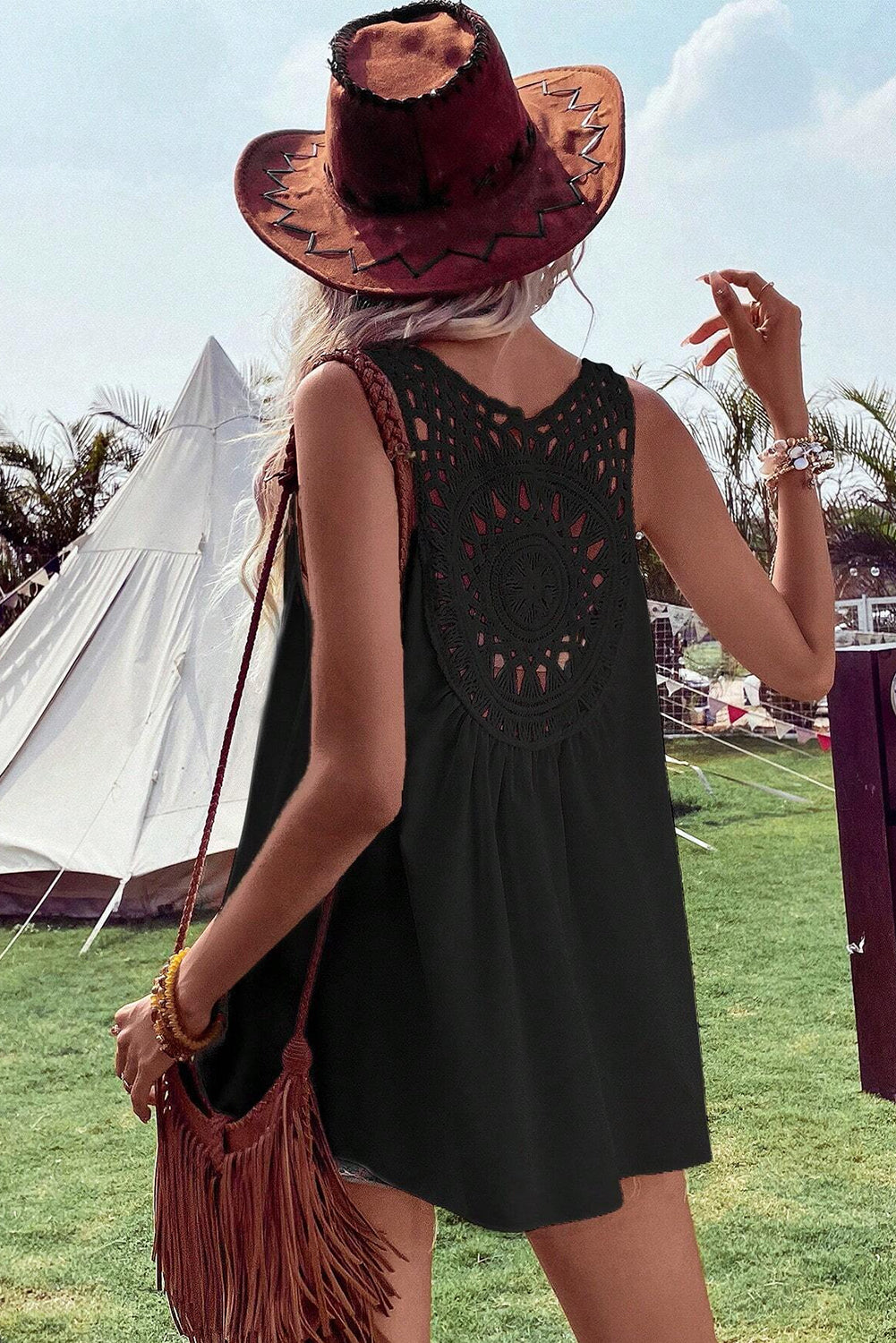 Black sleeveless tunic featuring crochet yoke with circular cutout motif and tiered skirt