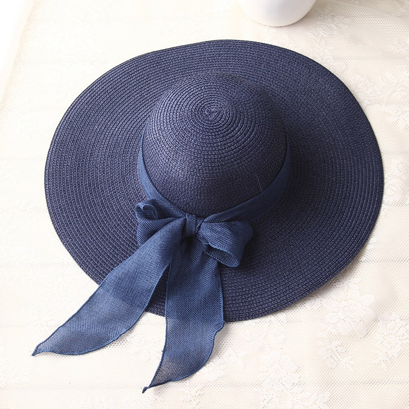 Dark blue wide-brim straw sun hat with large ribbon bow
