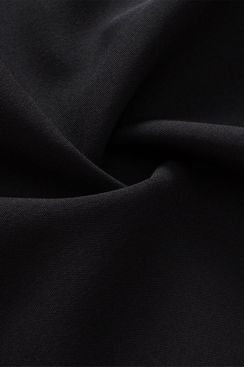 Black fabric close-up with soft drape and smooth woven texture