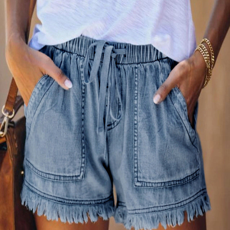 Blue denim shorts with elastic waist, drawstring, and frayed fringe hem