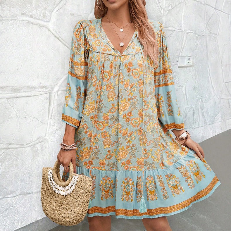 Light blue floral V-neck boho dress with orange trim at neckline and cuffs