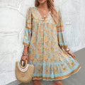 Light blue floral V-neck boho dress with orange trim at neckline and cuffs