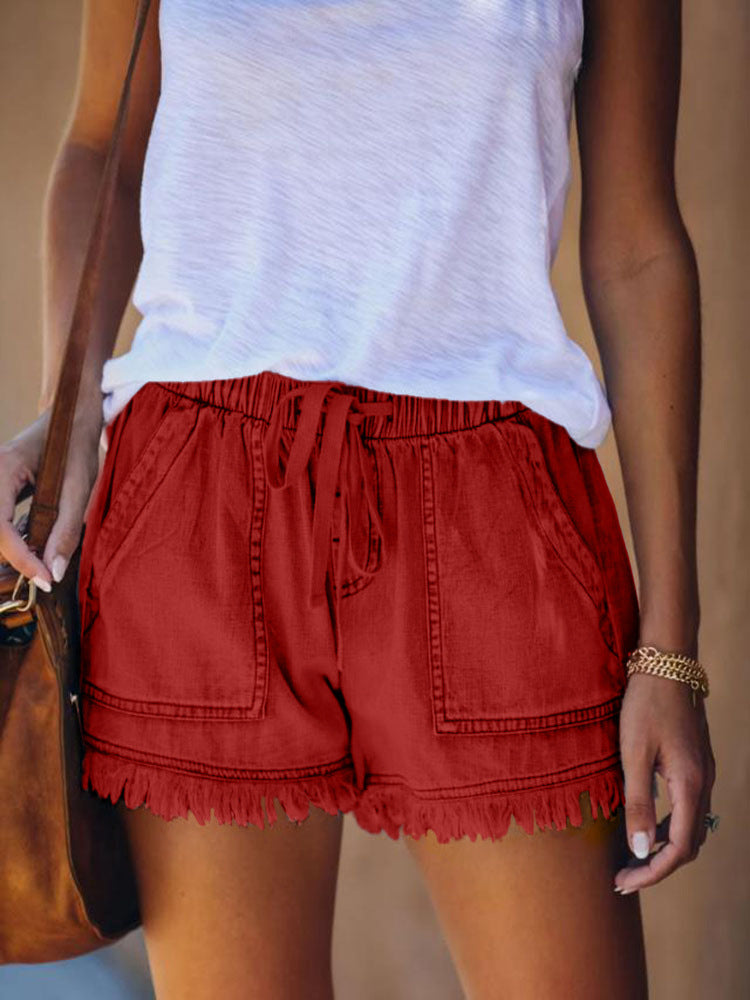 Red denim shorts with elastic waist, drawstring, and frayed fringe hem