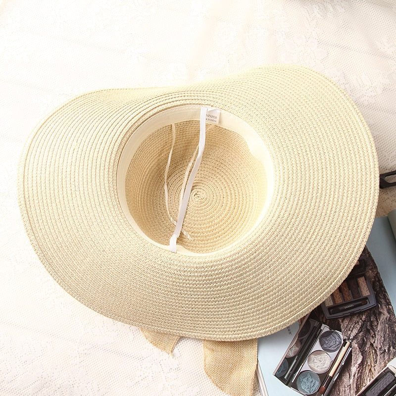 Cream wide-brim straw sun hat with beige ribbon bow