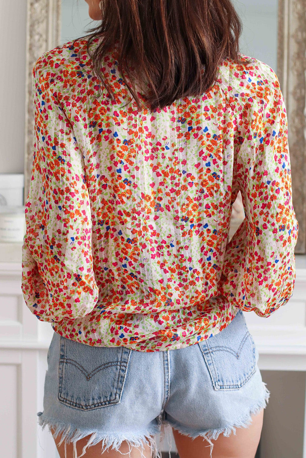 Multicolor floral blouse viewed from back with long puff sleeves and V-neck